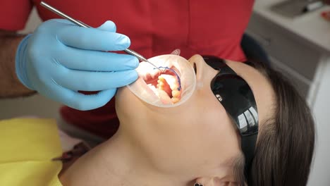 close-up shot of dentist in uniform looking at dental operating microscope hi-res. doctor using medical equipment. medicine and healthcare concept