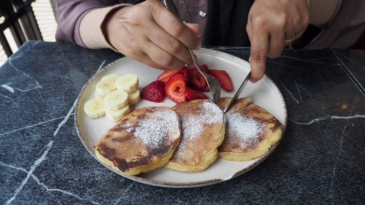 과일 과 초콜릿 소스와 함께 팬케이크를 먹는 여자