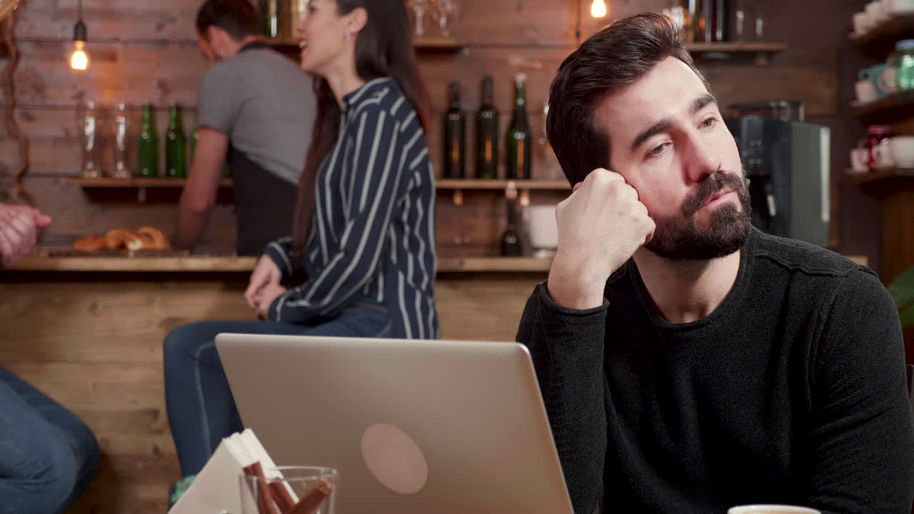 People in a bar using a laptop