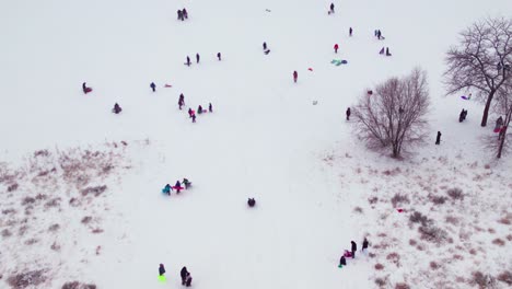 foto de un dron de niños jugando en una empinada colina nevada