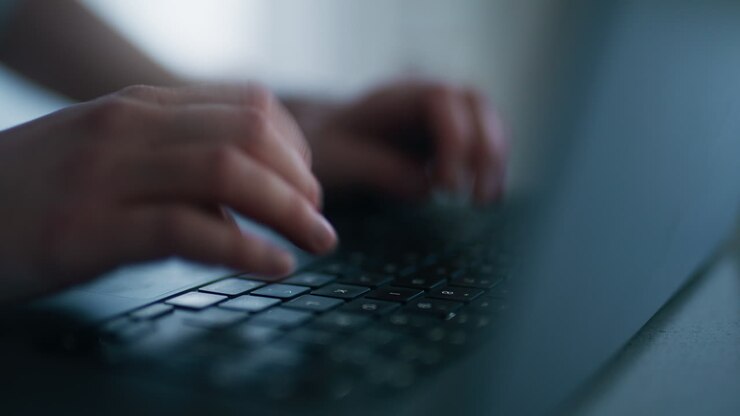 Eine E-Mail auf einem Laptop schreiben: Nahaufnahme von Händen auf der Tastatur