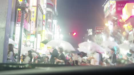 비가 내리는 도쿄 신주쿠의 교차로를 건너는 사람들