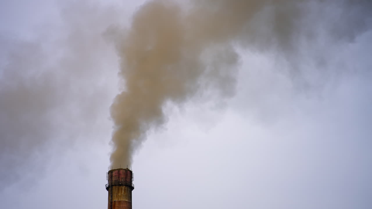 Smoking factory pipes. White smoke pours out of factory chimney in the air. Pollution, global warming concept. Aerial view video.