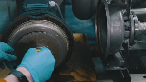 a worker is cleaning white water pumps with stone chicken pallets