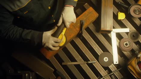trabajador pulindo metal con un molinillo. interior de una fábrica de la industria pesada con un trabajador usando un molino. molienda eléctrica de tubos de acero en una fábrica. cámara lenta. up close. video 4k. filmado en rojo