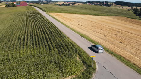 drone follows a car, initially from behind, then glides alongside, and later faces it head-on