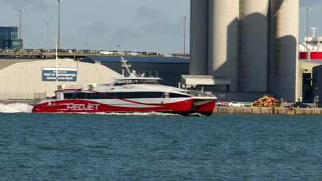 Statische-Aufnahmen-Einer-Katamaranfähre-Mit-Rotstrahlantrieb,-Die-Auf-Dem-Solent-In-Southampton-Ins-Bild-Kommt,-Mit-Weston-Im-Hintergrund