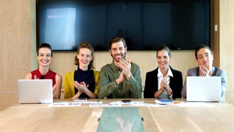 business team applauding during meeting in conference room