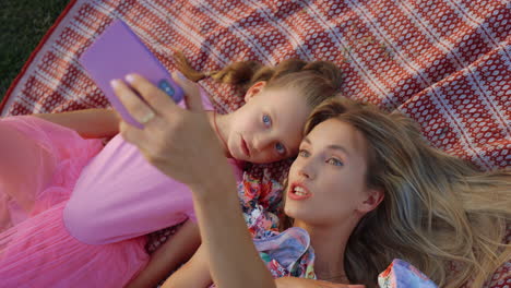 Schöne-Familie,-Die-Sich-Bei-Sonnenuntergang-Im-Stadtpark-Einen-Film-Auf-Dem-Handy-Ansieht