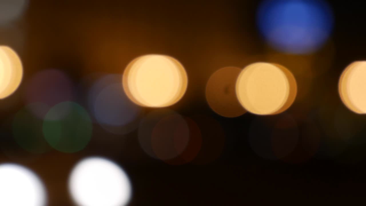 hermoso bokeh brillante en el fondo oscuro borroso por la noche. el redondo bokeh colorido brilla de las luces de los coches en la calle de la ciudad. fuera de foco con borroso. luces de la ciudad sin enfoque. bokeh de tráfico. concepto abstracto