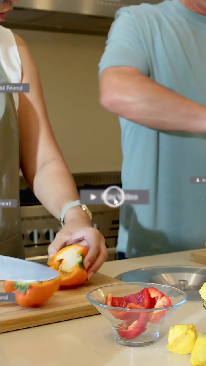 Video verticale: Donna che taglia un peperone, che tocca un tablet creando sovrapposizioni sopra il bancone per la preparazione dei pasti