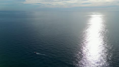 Croacia-Mar-Adriático-Puesta-De-Sol-Y-Reflejo-En-La-Superficie-De-Un-Pequeño-Bote-Que-Se-Mueve-A-Través-De-La-Toma-De-Un-Dron