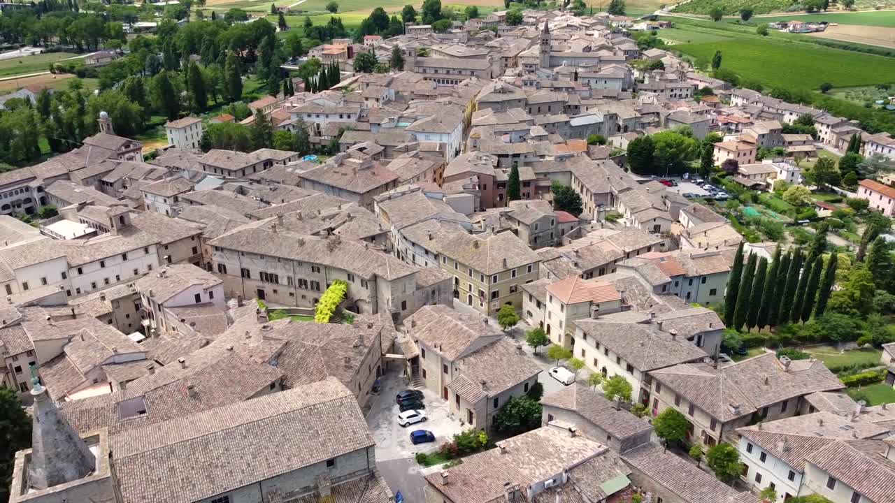 Ripresa aerea di un paesino in Italia di giorno, con vista ascendente.