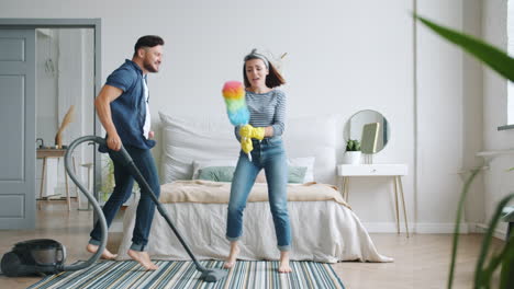 couple singing and dancing while cleaning