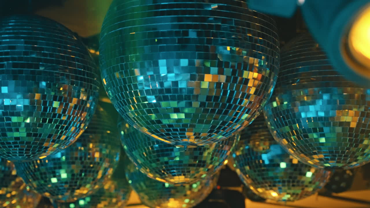Sfere da discoteca vibranti che riflettono raggi di luce colorati.