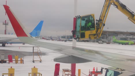 de icing of airplane before flight. anti-icing is the application of chemicals that not only deice but also remain on a surface and continue to delay the reformation of ice