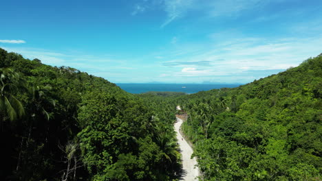 aerial flyover tropical highlands on koh phangan island and ocean in background during sunny day, thailand