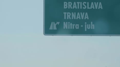 Traffic-sign-on-highway-with-Bratislava-and-Trnava-in-Slovakia,-passing-by