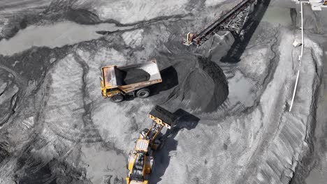 Excavator-loading-quarry-on-dump-trailer-during-sunny-day-in-american-mine-site