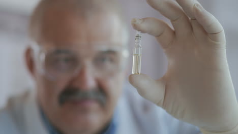 a pharmacist holds a medicine in ampoules made of glass. a new drug to fight viruses and diseases. medicine for coronavirus. high quality 4k footage