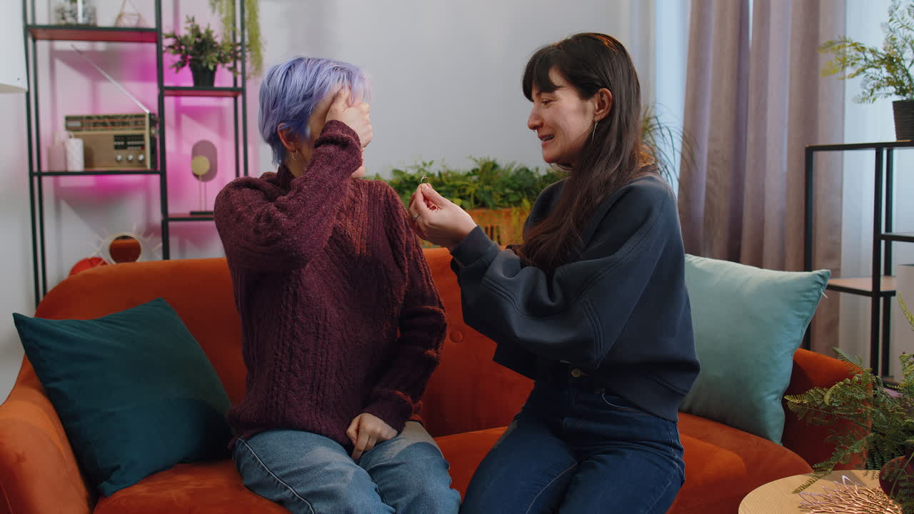 Two lesbian women family couple girl gay making surprise engagement ring love proposal of marriage