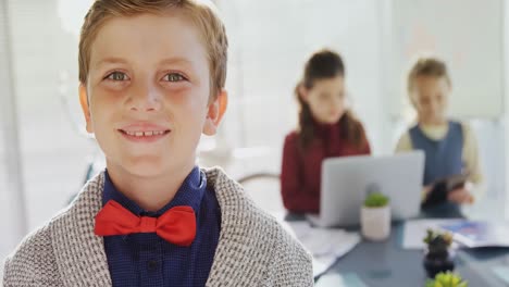 Boy-as-business-executive-smiling-while-standing-in-office--4k