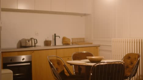 Empty-cozy-kitchen-with-dinning-table,-wide-handheld-view