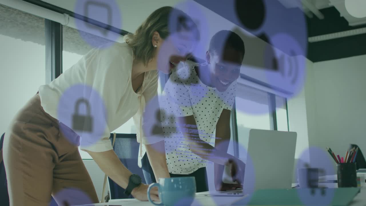 Two women leaning over laptop, pointing and typing, causing purple icon overlay during tech review