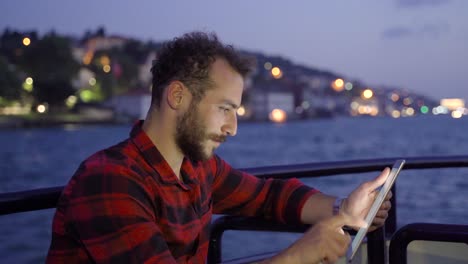 man using tablet on ferry. working.