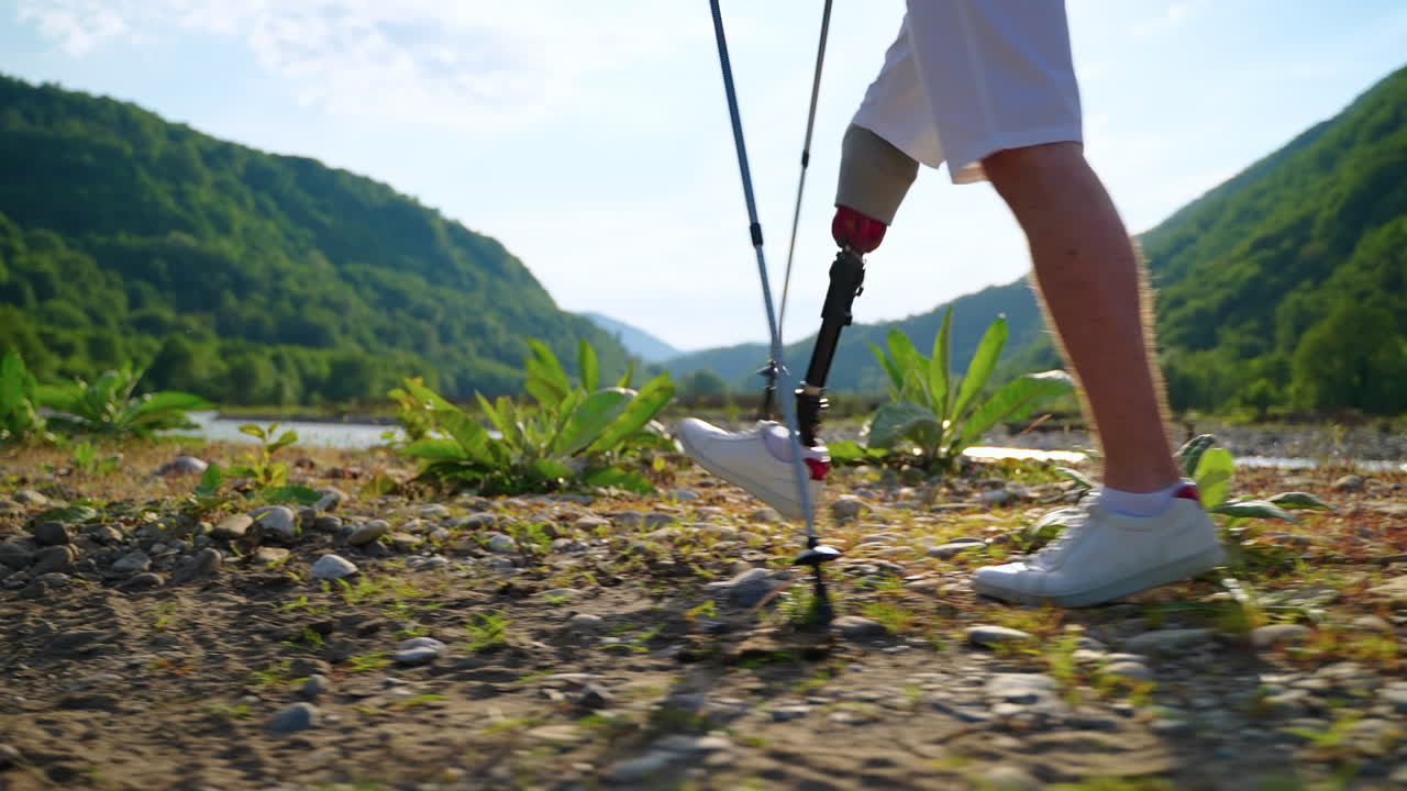 足の義肢を身に着けている人が山を登っている