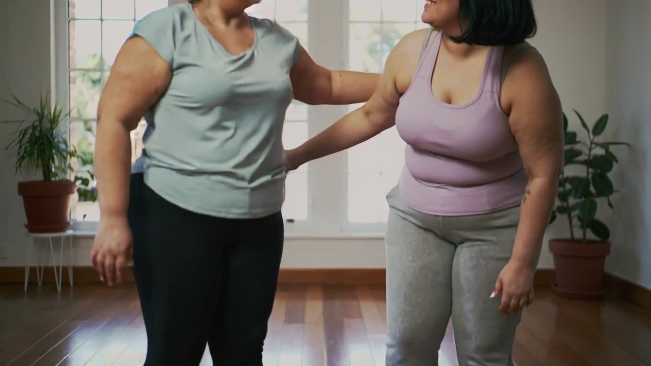 Due donne che posizionano tappetini yoga viola e bottiglie d'acqua, si allineano e si abbracciano prima dell'allenamento.