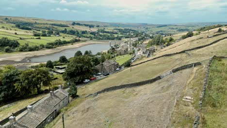 Aerial-footage-of-a-rural-industrial-village-with-old-mill-and-chimney-stack-surrounded-by-fields