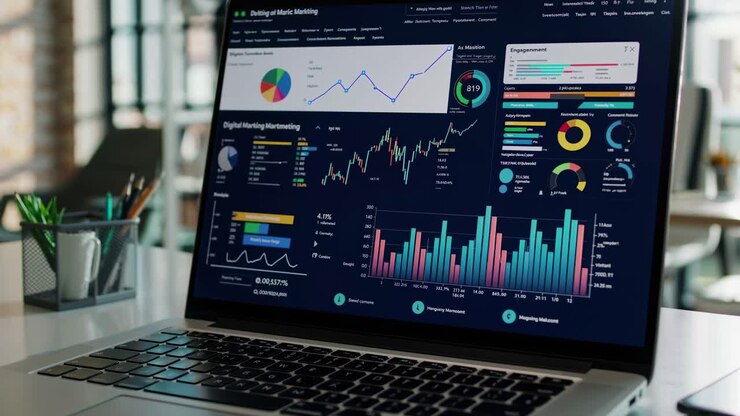 A modern office setting with a laptop displaying analytics. Captured from a side angle, perfect