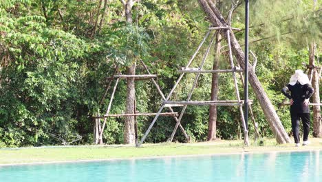 individual walking by a pool with trees