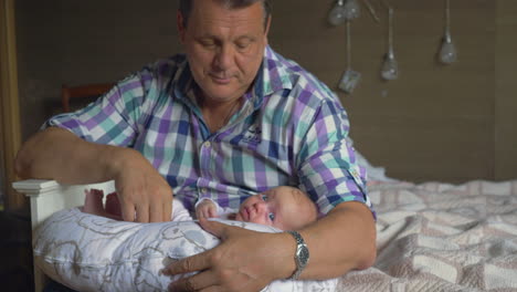 abuelo cuidando a un nieto de dos meses