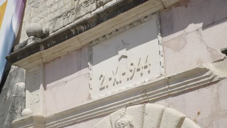 close up of inscription above the sea gate entrance of the city walls old town in kotor montenegro showing a start and 21 - xi - 1944 detail historical military building