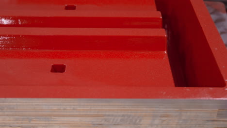 close-up of a red mechanical toolbox drawer, highlighting the glossy finish and precision square holes