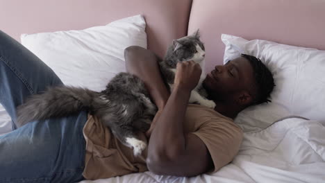 pet owner with his cat on bed