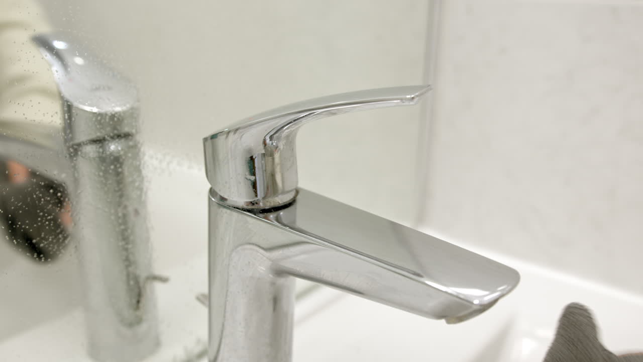 Pulizia del calcare da un rubinetto del bagno, primo piano