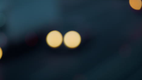 los faros borrosos de los coches se mueven por la noche en la carretera efecto bokeh.