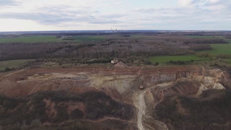 flight towards a heavy equipment giant walking excavator in an excavated quarry