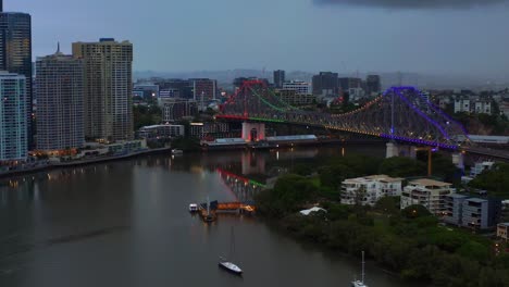 aerial view of story bridge with colorful lights over brisbane river in brisbane, qld, australia