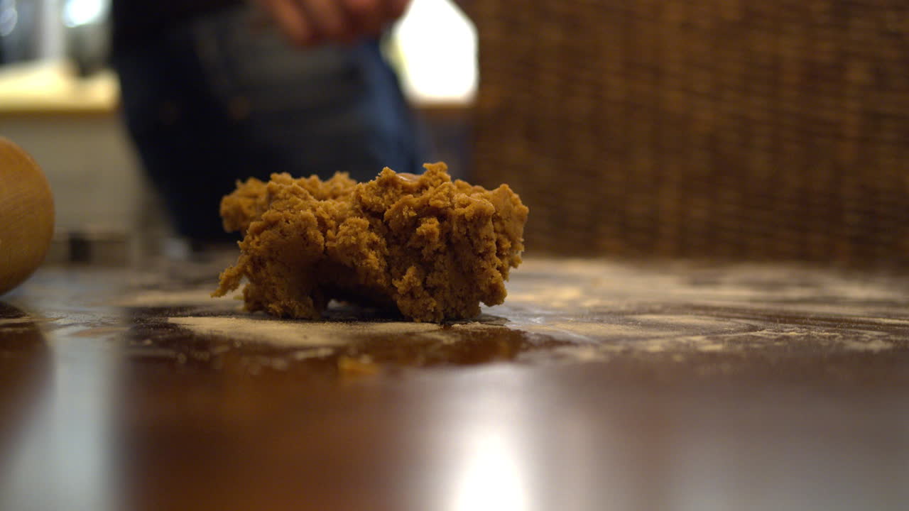 dejando caer un trozo de masa de pan de jengibre sobre la mesa cubierta de harina