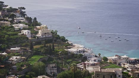 aerial view of capri village, sea and boats passing during a sunny day