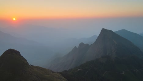 aerial drone shot of kolukkumalai range at daybreak, glowing in soft morning hues