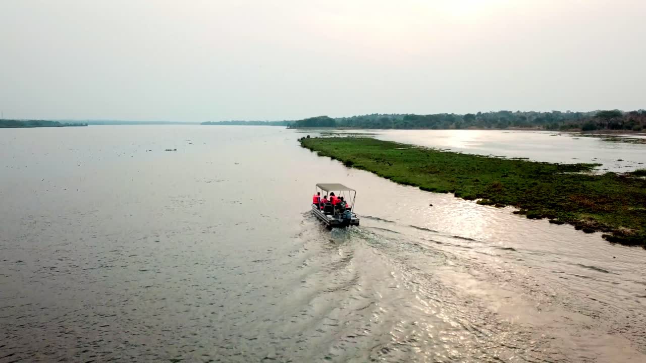 밝은 태양에 의해 햇볕이 비치는 호수를 가로질러 항해하는 모터보트를 타고 휴가를 즐기는 사람들
