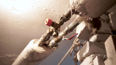 water valves and metal pipes under a well lit area inside a home basement