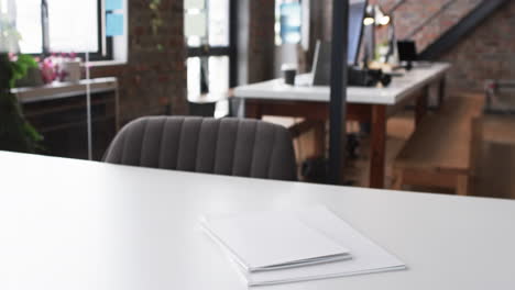 A-white-desk-with-a-closed-laptop-and-papers-in-a-modern-business-office-with-copy-space