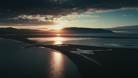 Increíble-Y-épico-Dron-Y-Toma-Aérea-Del-Sol-Poniente-Contra-Un-Puente-Y-Una-Serie-De-Lagos-Con-Montañas-En-La-Distancia