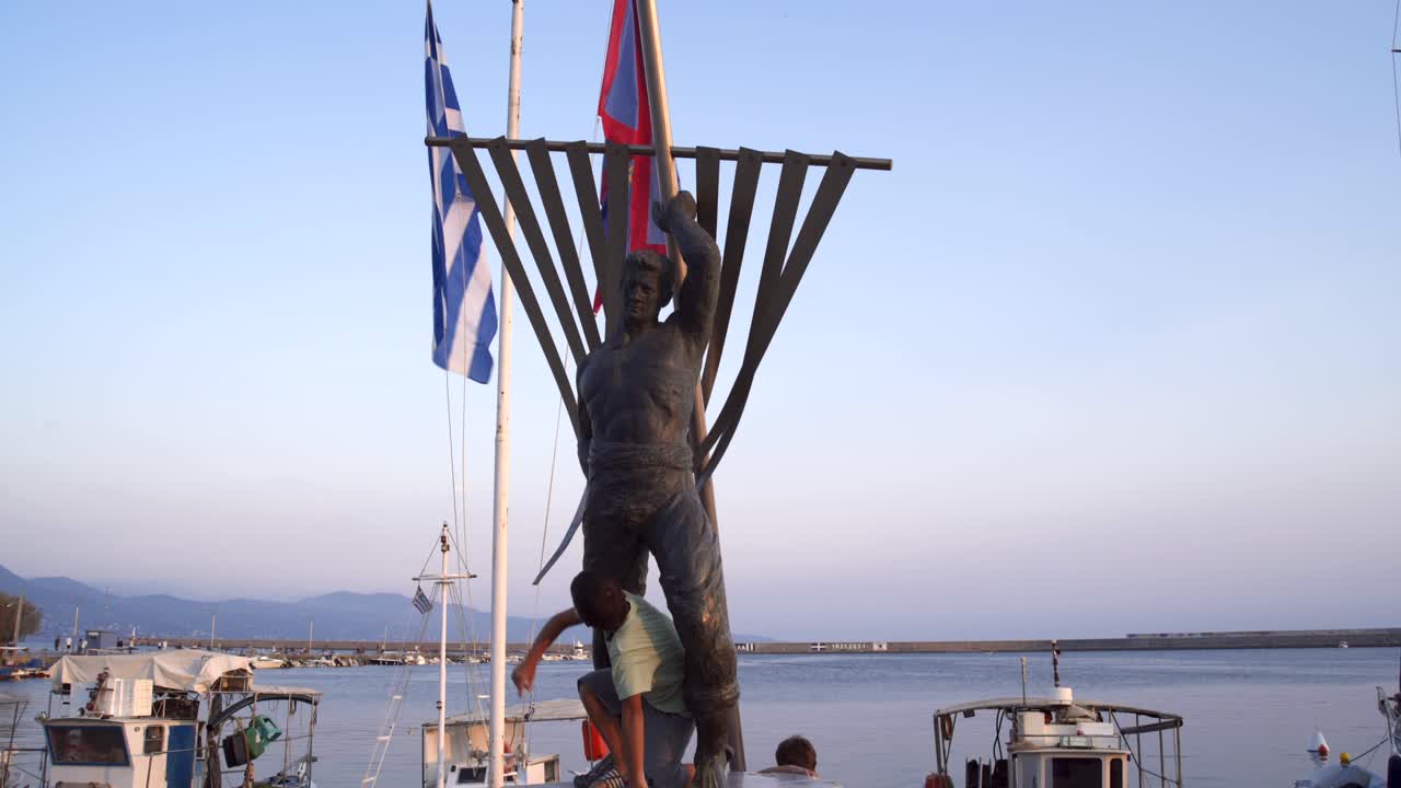 두 백인 형제는 그리스 펠로폰네소스 지방의 작은 항구인 칼라마타에 있는 선원의 청동 동상 에 서 있다.